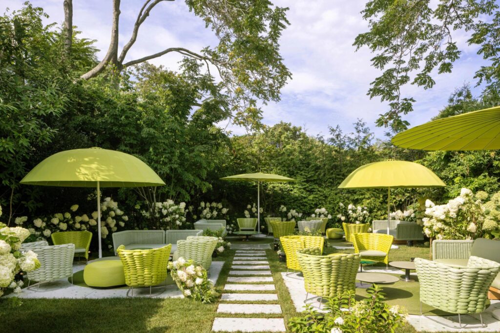 The lush garden of the new Rolex boutique Hamptons, featuring green outdoor lounge areas for a private hospitality experience.